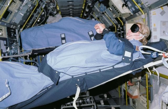NASA image: STS-40 MS Seddon, wearing blindfold, sleeps in SLS-1 module