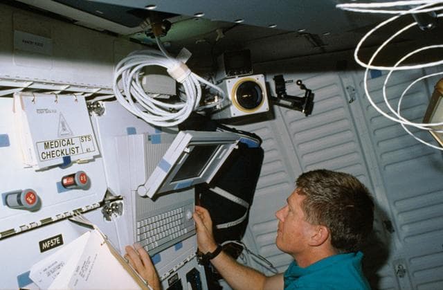 NASA image: STS-41 MS Shepherd uses DTO 1206 portable computer on OV-103's middeck