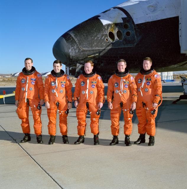 NASA image: STS-41 crew poses in front of OV-103 on concrete runway 22 at EAFB, Calif