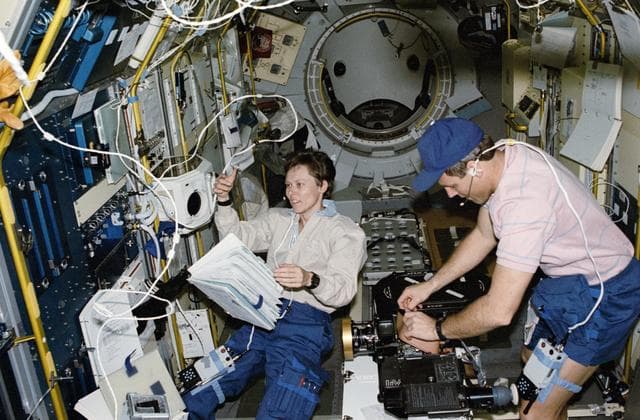 NASA image: STS-42 crewmembers work in the IML-1 module located in OV-103's payload bay