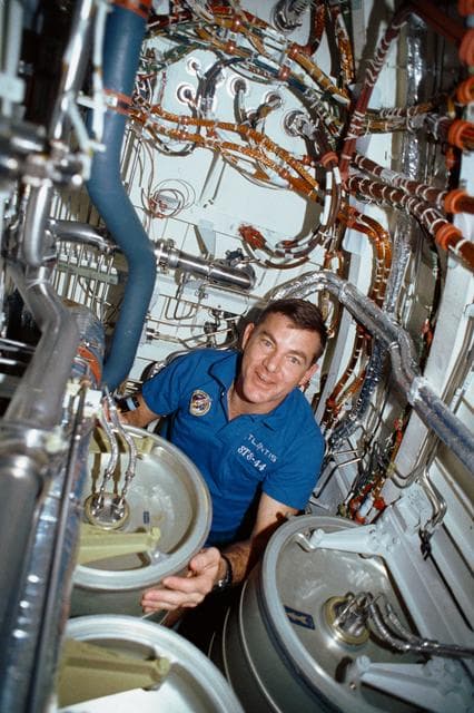 NASA image: STS-44 MS Voss "Bilge Man" under OV-104's middeck subfloor repairs separator