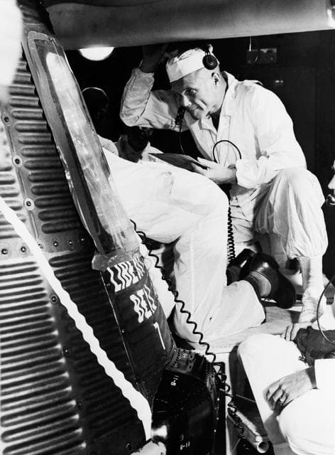 NASA image: Astronaut John Glenn and technician examine interior of Liberty Bell 7