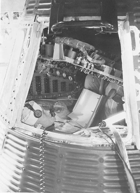 NASA image: Astronaut John Glenn inspecting interior of Mercury capsule