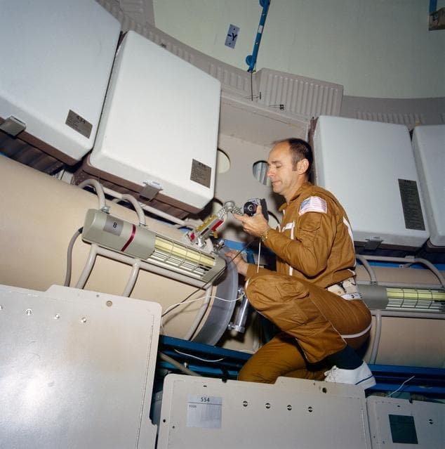 NASA image: Astronaut Alan Bean looks over data acquisition camera on Skylab trainer