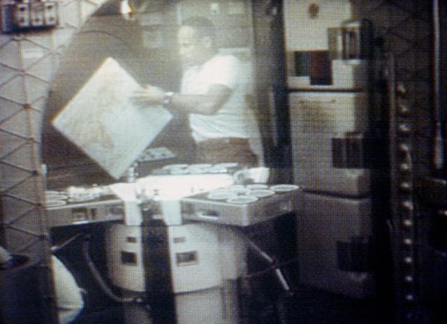 NASA image: Astronaut Jack Lousma looks at map of Earth in ward room of Skylab cluster