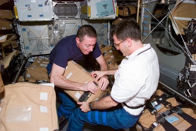 NASA image: STS-81 crew packs hardware for stowage in the Spacehab
