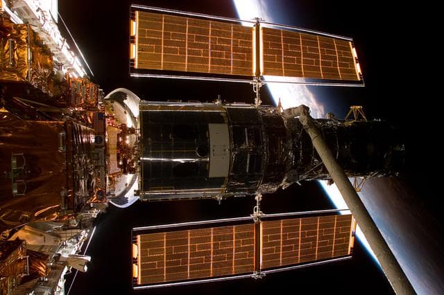 NASA image: HST,survey views of Hubble after berthing in payload bay on Flight Day 3