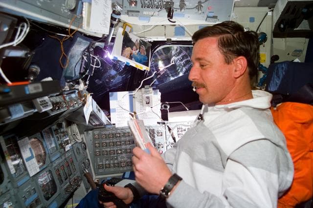 NASA image: Pilot Scott Horowitz consults a checklist during a Vernier burn