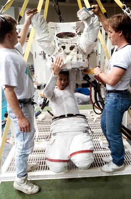 NASA image: STS-38 Mission Specialist (MS) Robert C. Springer dons EMU in JSC's WETF