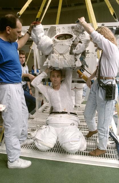 NASA image: STS-38 Mission Specialist (MS) Carl J. Meade dons EMU in JSC's WETF Bldg 29