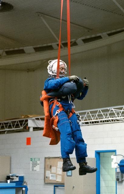 NASA image: STS-39 MS Bluford is suspended over JSC's WETF Bldg 29 pool via harness