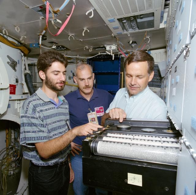 NASA image: Student experimenter stands near middeck lockers in JSC Bldg 9A mockup