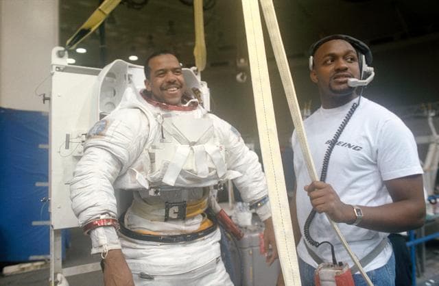 NASA image: STS-55 MS3 Harris dons EMU with technician's assistance in JSC's WETF Bldg 29
