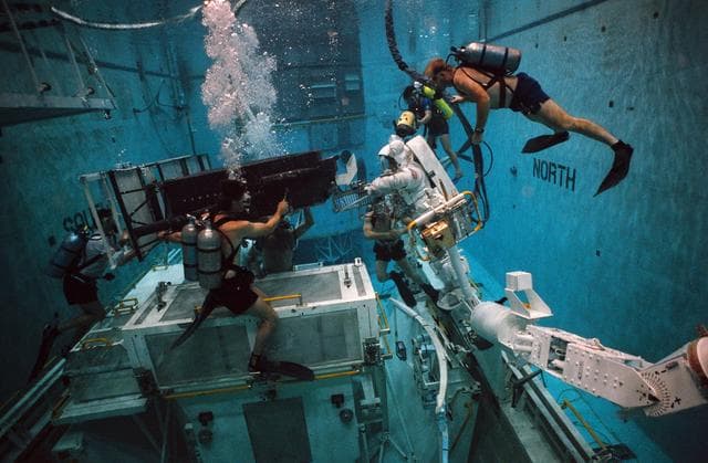 NASA image: STS-61 crewmembers in the WETF rehearsing for HST repair mission