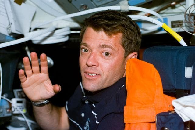 NASA image: Pilot Ashby waves from the pilot's seat in the flight deck