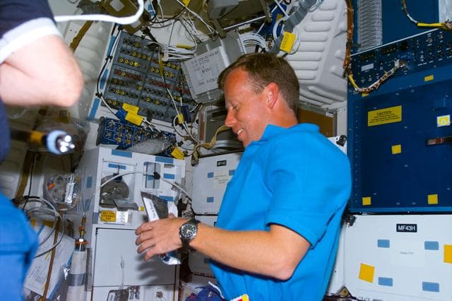 NASA image: Lindsey rehydrates drink packet on middeck