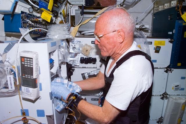 NASA image: Glenn works with experiment on middeck
