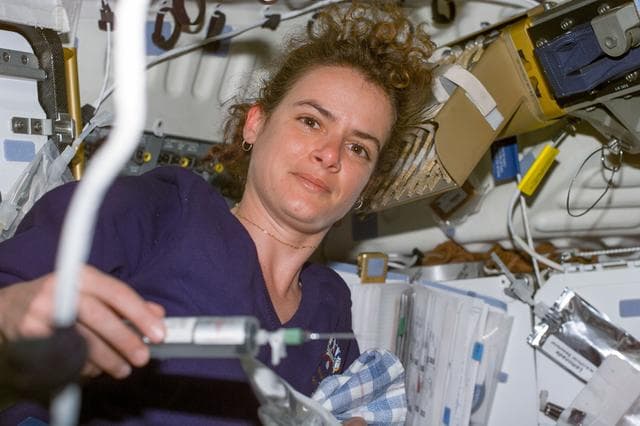 NASA image: Julie Payette prepares to remove air bubbles from EVA drink packets