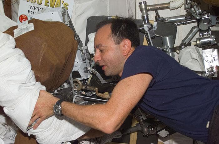NASA image: PLT Polansky helps crewmember with his EMU boot