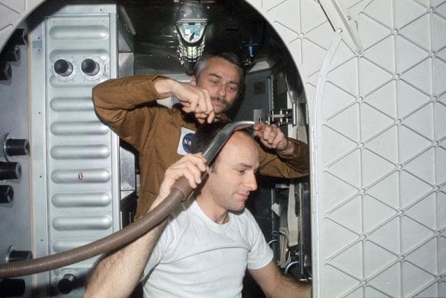 NASA image: Astronaut Owen Garriott trims hair of Astronaut Alan Bean