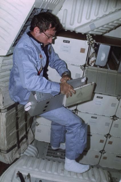 NASA image: Commander Young removes CAP from FDF stowage locker on middeck