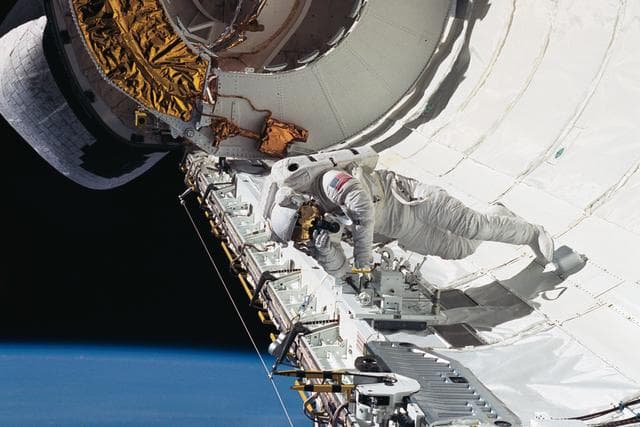 NASA image: Astronaut James Newman evaluates tether devices in Discovery's payload bay