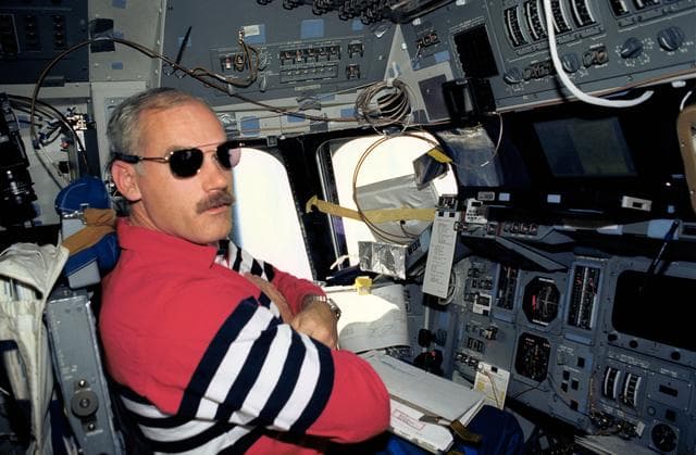 NASA image: Astronaut William Readdy on flight deck wearing sun glasses