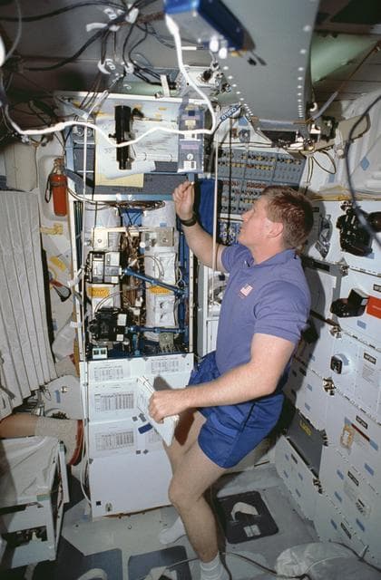 NASA image: Crewmember in the middeck tending the CVTE and LBNP experiments.