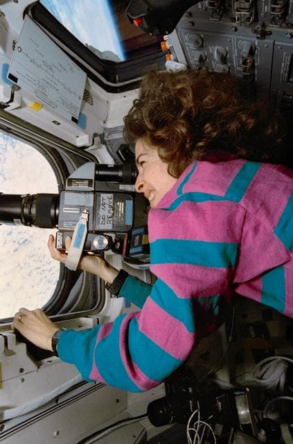 NASA image: STS-56 MS3 Ochoa points HASSELBLAD 70mm camera out OV-103's overhead window
