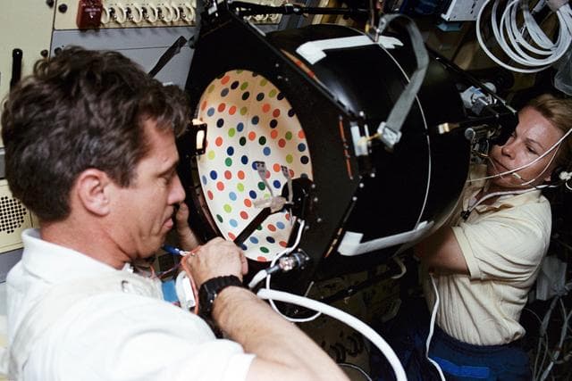 NASA image: Crewmembers in the spacelab with the Rotating Dome vestibular experiment.