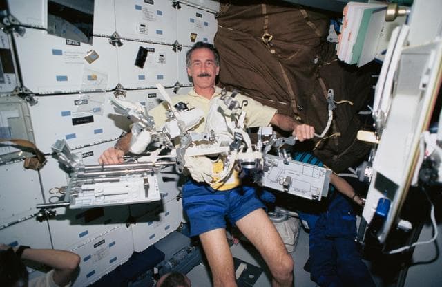 NASA image: Astronaut Jeffrey Hoffman displays tools for use on HST