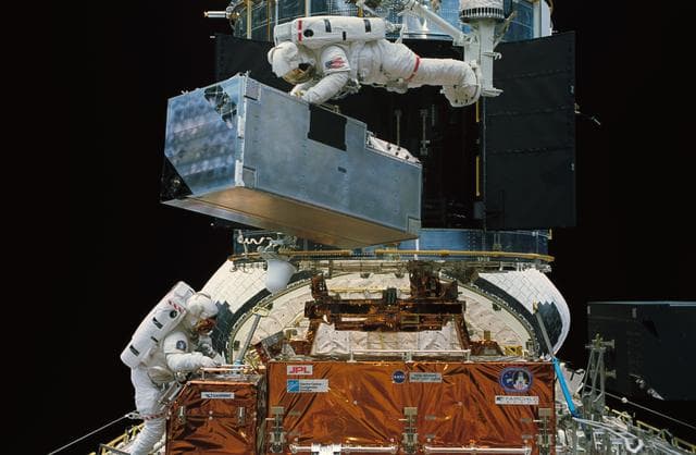 Astronauts Thornton and Akers in payload bay during EVA to replace COSTAR