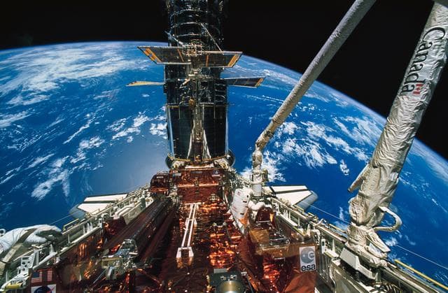 Astronaut Story Musgrave during deployment of solar array panels on HST