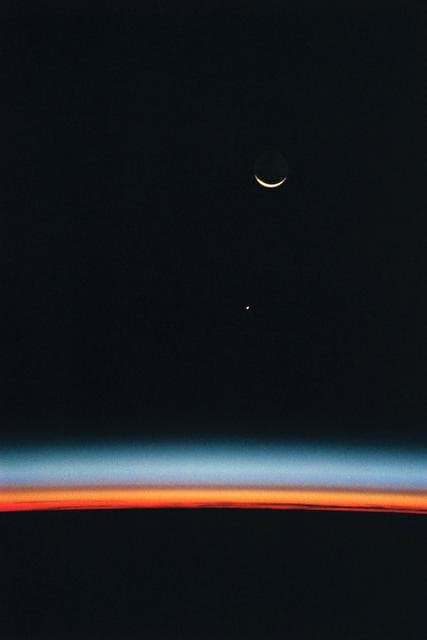 NASA image: Earth-orbiting HST, airglow over Earth's horizon, and crescent moon