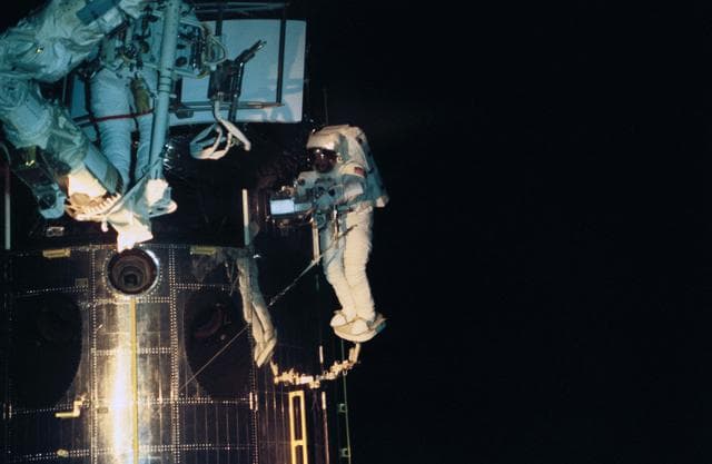 Astronaut Jeffrey Hoffman works with replacement WF/PC II for HST