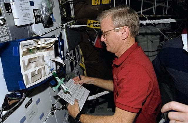 NASA image: Astronaut John Casper checks equipment to support medical testing