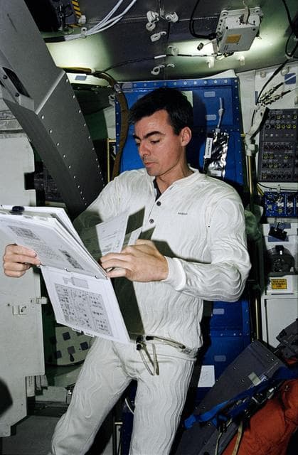 NASA image: Astronaut Andrew Allen looks over procedure book in middeck