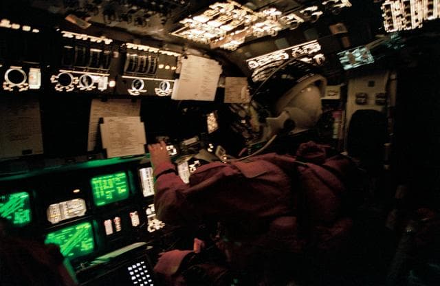 NASA image: Astronaut Andrew Allen monitors Columbia's systems from pilots station