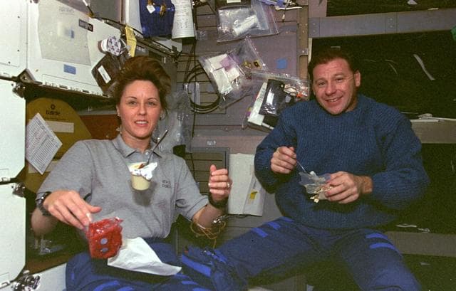 NASA image: Thornton and Sacco eating; Sacco typing on PGSC