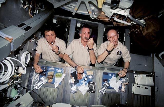 NASA image: Astronauts Chang-Diaz, Hoffman and Nicollier eating in their sleep racks