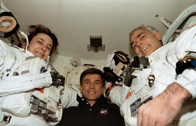 NASA image: Linda Godwin and Michael "Rich" Clifford are assisted out of their EMU suits