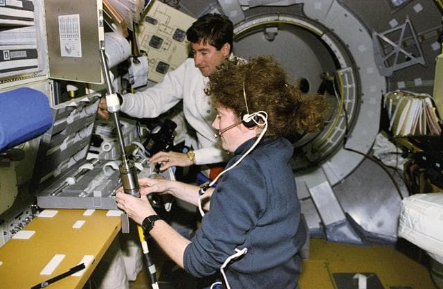 NASA image: AGHF, Helms removes a sample from the LMS-1 Spacelab core facility module