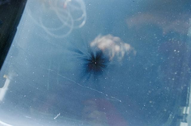 NASA image: Views of the overhead flight deck window showing debris impact damage