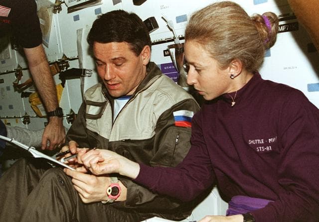 NASA image: STS-81 Cmdr and MS Ivins with Mir 22 Cmdr review transfer checklists
