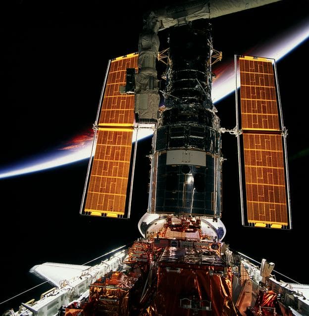 NASA image: HST, full length views of telescope in payload bay after capture and berthing