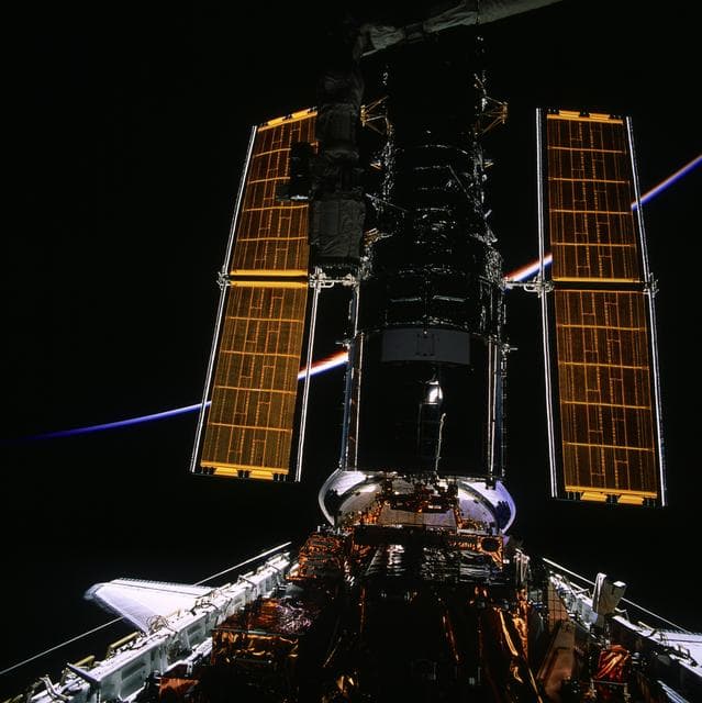 NASA image: HST, full length views of telescope in payload bay after capture and berthing