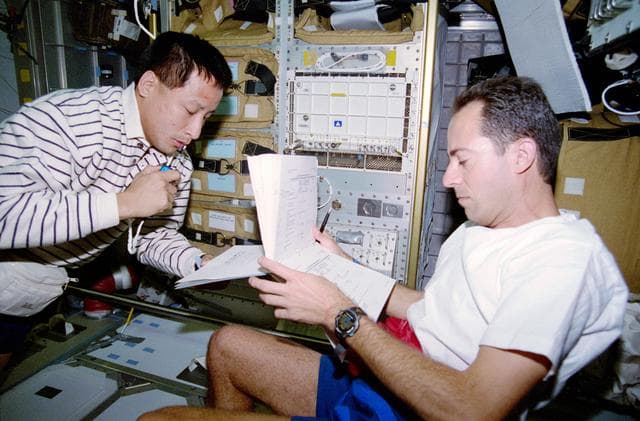 NASA image: Lu and Clervoy discuss transfer operations in the Spacehab