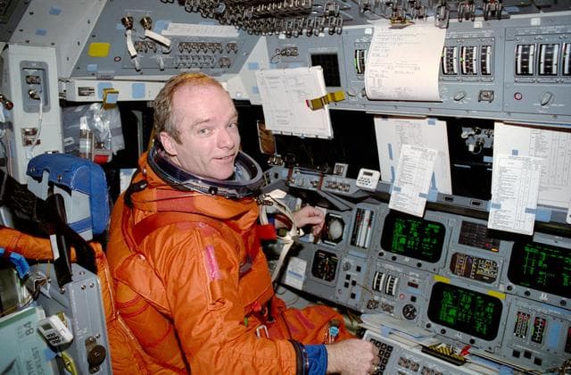 NASA image: Precourt prepares for entry seated at the commander's station