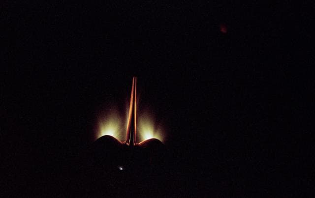 NASA image: View of OMS burn and illuminated orbiter stabilizer