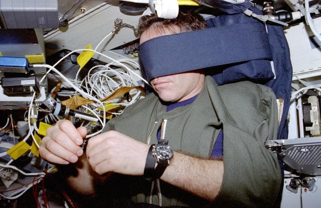 NASA image: Kadenyuk sleeps strapped to the middeck wall